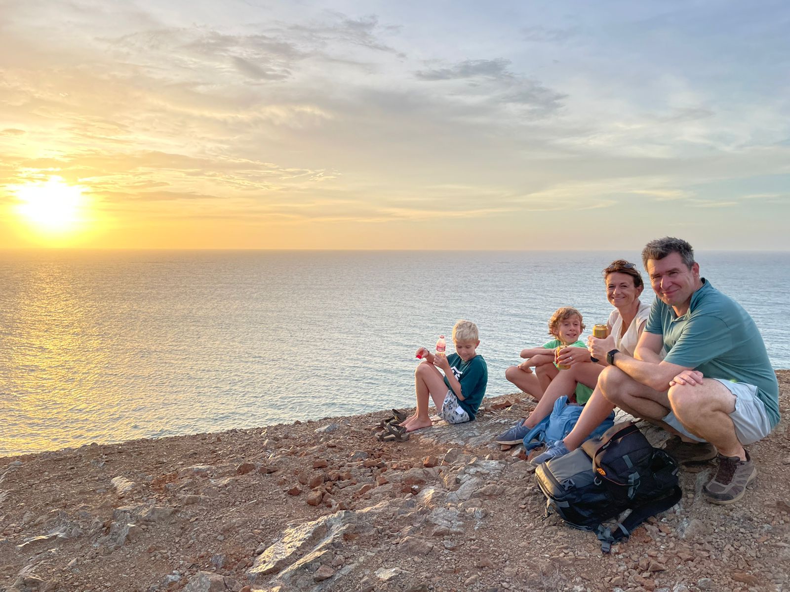 Familia viendo el atardecer en la playa